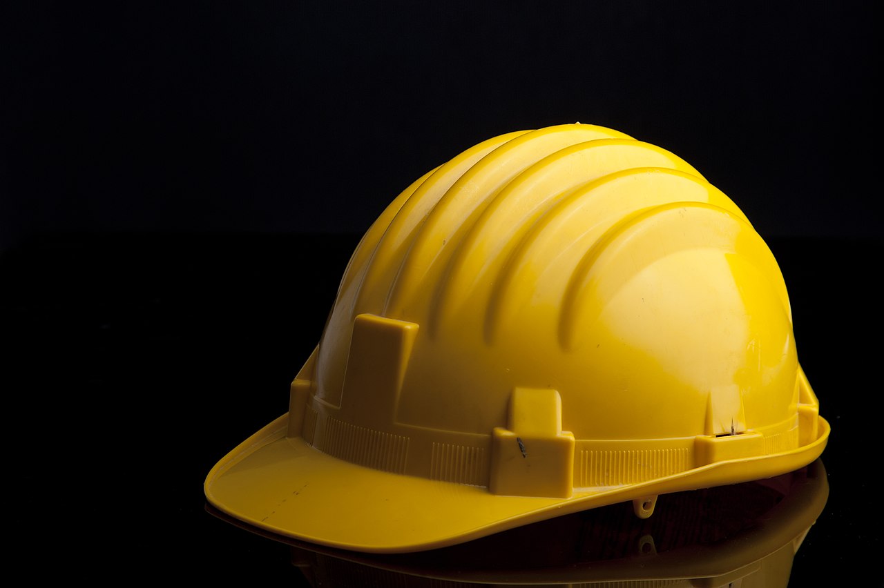 Yellow industrial safety helmet on a black background